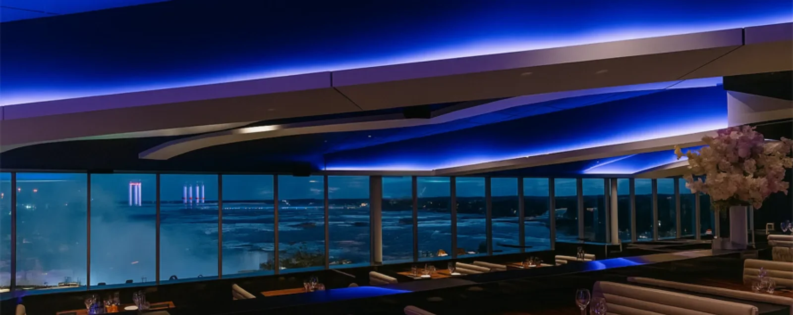 The STK Steakhouse dining room at night with blue lighting and a view over the falls