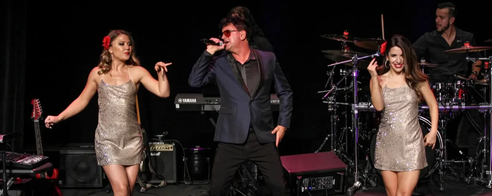 A live Latin band performing on stage with two dancers